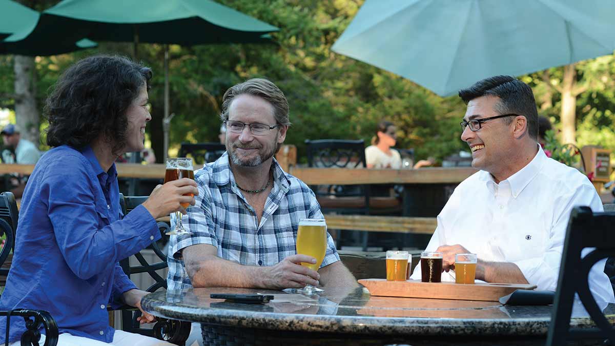 A group with their beers sitting on the patio at Hamburg Brewing Company