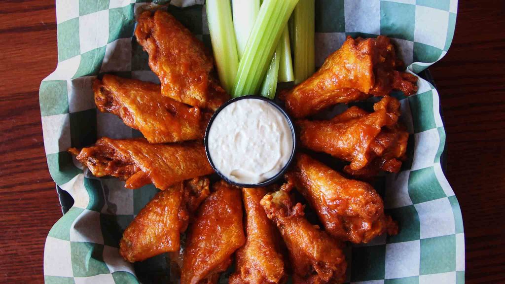 A plate of Bar-Bill Tavern buffalo wings with celery and blue cheese dip, a classic in East Aurora.