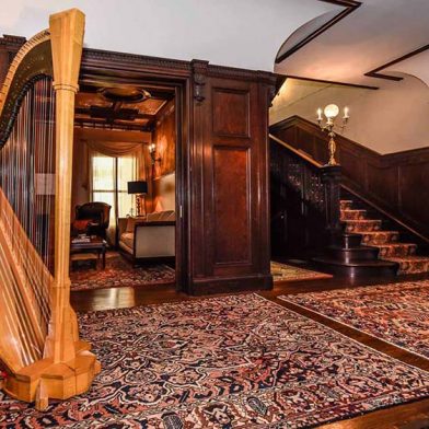 Interior shot of the common area, featuring a harp, at Inn Buffalo