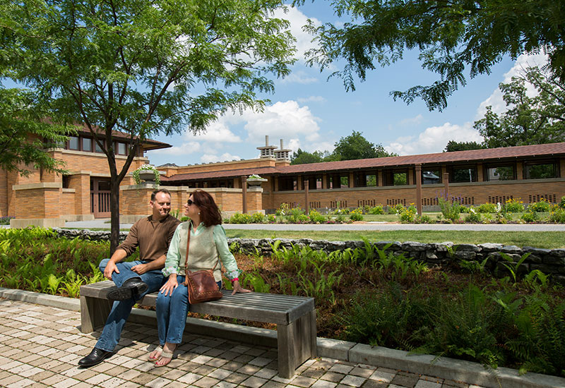 A couple sitting on a bench at the Frank Lloyd Wright Martin House