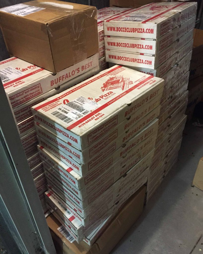 Boxes of pizza ready to ship at Bocce Club Pizza.